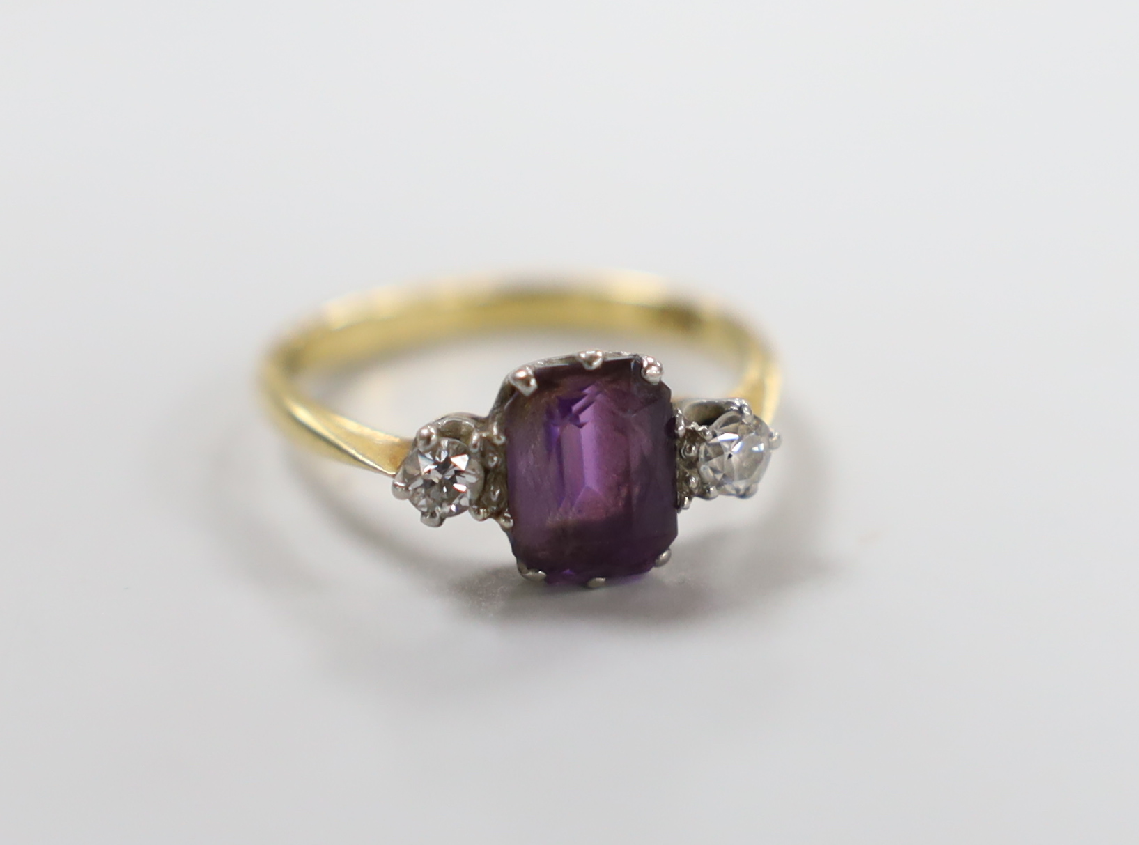 An 18ct, single stone amethyst and two stone diamond set ring, size N, gross weight 3 grams.